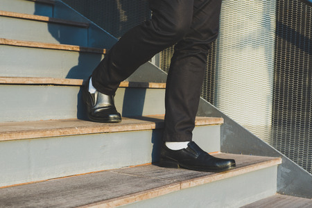 Businessman legs walking up the stairsの写真素材