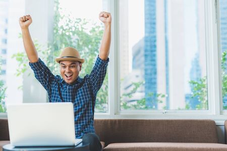 asian businessman celebrate with laptop finish work success poseの写真素材