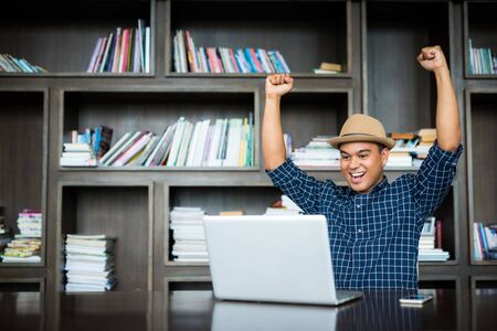 asian businessman celebrate with laptop finish work success poseの写真素材