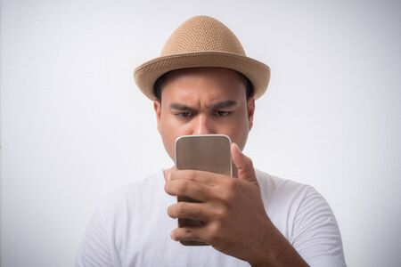 Young asian man looking smartphone and confused