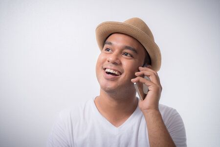 Asian man happy with his smartphone on white background.の写真素材