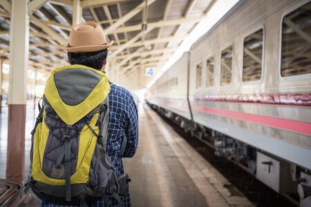 Young man standing at train stationの写真素材