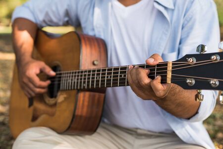 Young asian man playing guitar the parkの写真素材