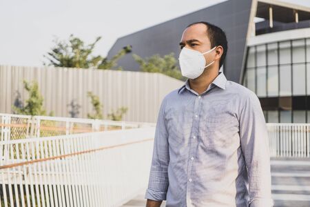 Man wearing facial hygienic mask nose outdoors. Air pollution concept.の写真素材