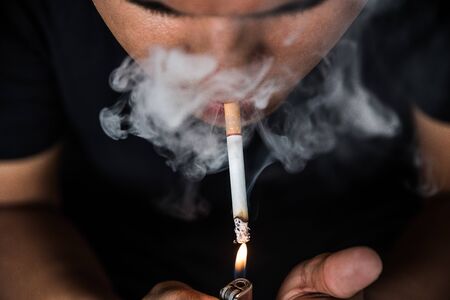 Close up young man smoking a cigarette.