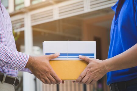 Hand accepting a delivery of boxes from deliveryman.の写真素材