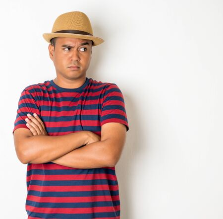 Asian men around the age of 27-35 are thinking and making faces, confused, not understanding, wondering with something. This photo was taken in the studio. With a white backgroundの写真素材