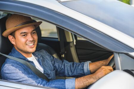 Asian men are driving carefully. And smile happily with this tripの写真素材