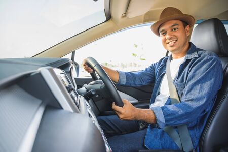 Asian men are driving carefully. And smile happily with this trip