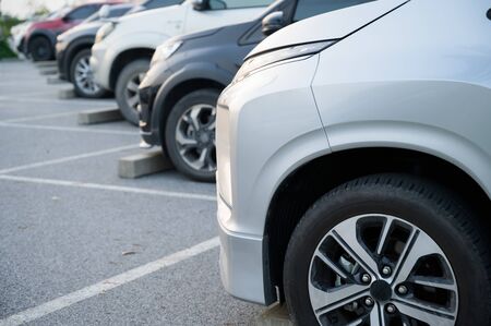 Many cars are parked in a large parking lot. Arranged in a long line Was the time when the sun was...