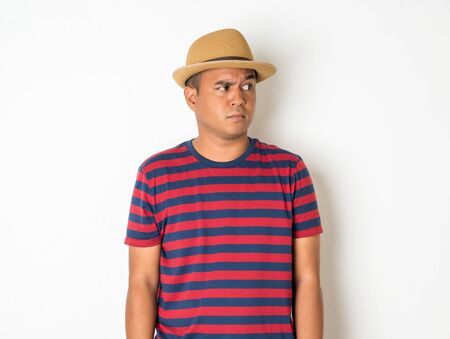 Asian men around the age of 27-35 are thinking and making faces, confused, not understanding, wondering with something. This photo was taken in the studio. With a white backgroundの写真素材