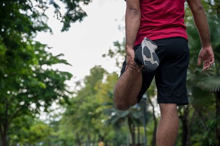 Young fitness man runner stretching before run healthy lifestyle and sport concepts