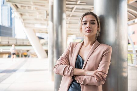 Portrait of smiling pretty young business woman with arms crossed on office background.の写真素材