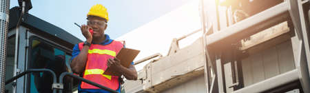 Black foreman worker working control the crane and forklift at Container cargo harbor to loading...