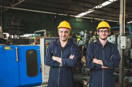 Industrial workers are working on projects in large industrial plants with many devices.