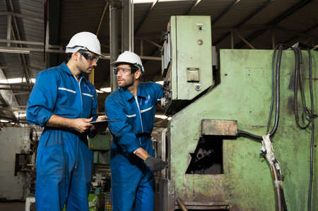 Industrial workers are working on projects in large industrial plants with many devices.