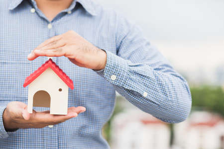 Hand holding mockup house. Real estate loan insurance buy and sell home concept.