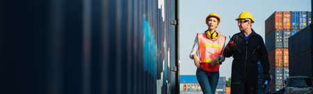 Two foreman man & woman worker working checking at Container cargo harbor to loading containers. Dock male and female staff business Logistics import export shipping concept.の写真素材