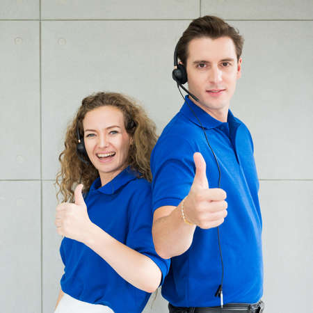 Customer support operator at work. Team Business and Delivery call center in office. Working with a headset in blue uniform.の写真素材