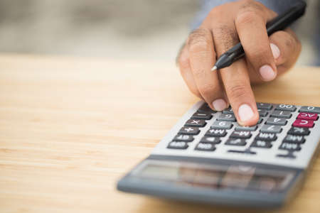 Male hand using calculator to Calculate income financial money investment concept.