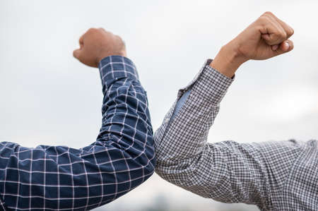 Two businessmen Shaking elbows keeping social distancing.の写真素材