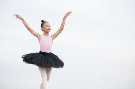 Asian ballerina girl dancing on the rooftop of the building city background.