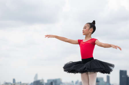 Asian ballerina girl dancing on the rooftop of the building city background.の写真素材