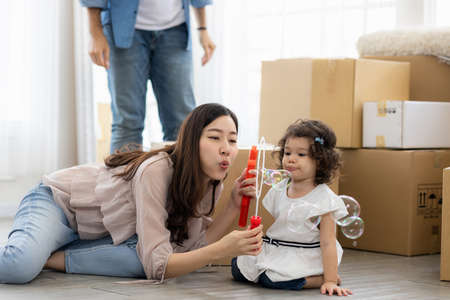Happy time family blow soap bubbles relax in living room. Everyone having fun in the house.
