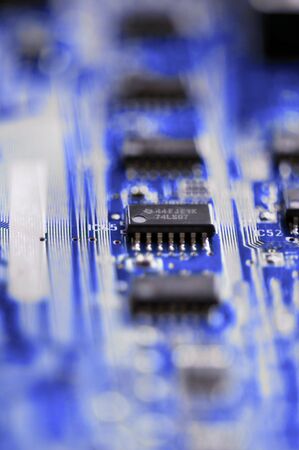 Circuit board detail with microchips on blue blurry background