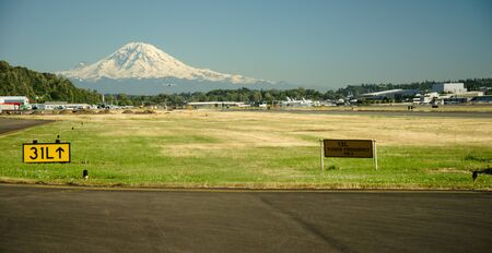 Mt Rainier towers above approach end of Boeing Field as small airplane approachesのeditorial素材