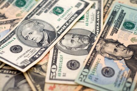 Money spread out with focus on the portraits on the 10, 20, and 50 dollar bills の写真素材