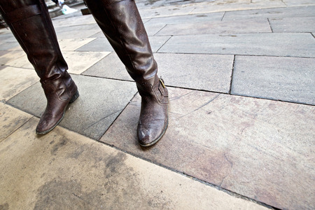 Angled close up of woman's legs and dirty bootsの写真素材