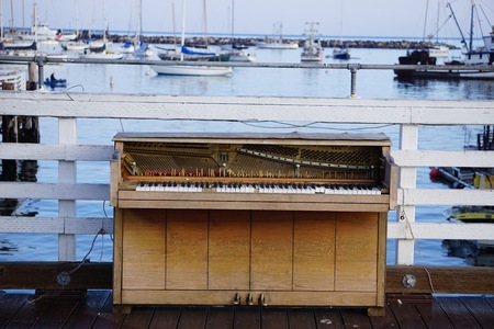 abandoned broken piano on the ocean dockの写真素材