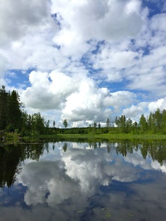beautiful blue sky day clouds reflecting on waterの写真素材