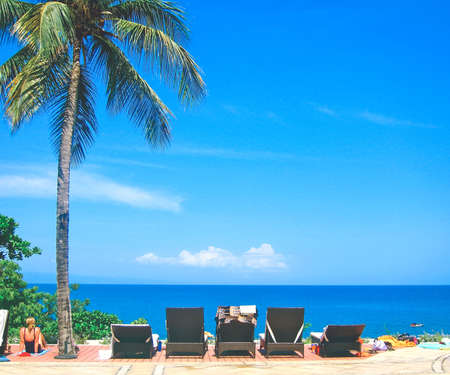 relaxing resort lounge chairs at the beachの写真素材