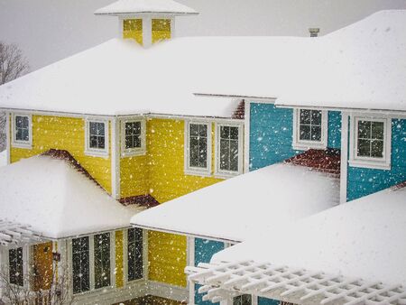 snow falling on colorful housesの写真素材