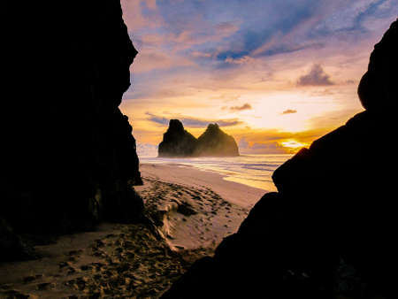 sunset and ocean through the rocksの写真素材