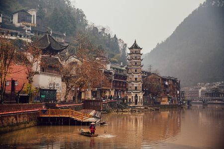 A man fishing on the river in ancient Phoenix Town, Chinaのeditorial素材