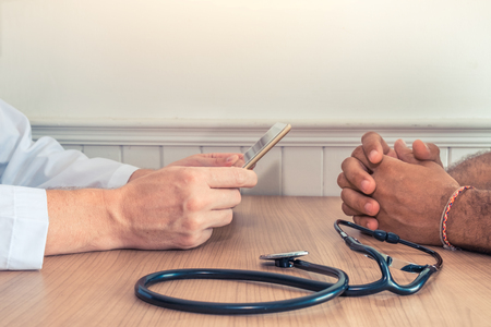 Doctor holding a digital tablet with x-ray with the patient in the officeの写真素材