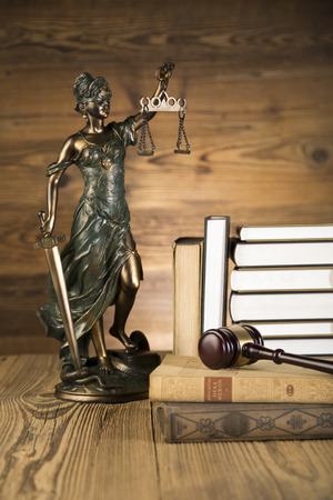 Lady of justice, final speech, notebook, wooden   gold gavel and books on wooden table on brown wooden の写真素材