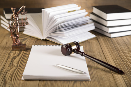Goddess of justice, final speech, notebook, wooden   gold gavel and books on wooden table on brown...