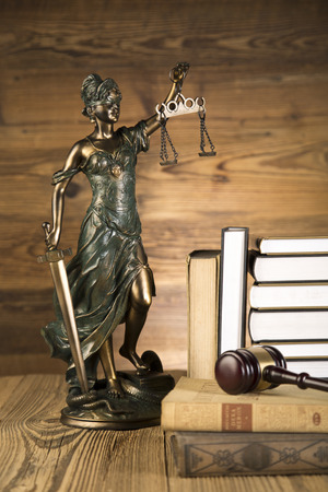 Lady of justice, final speech, notebook, wooden   gold gavel and books on wooden table on brown wooden の写真素材