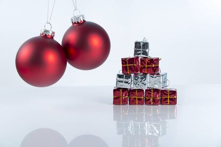 Christmas background with a colorful ornament, gift box, berries and fir in snow isolatedの写真素材