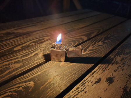 A classic lighter standing on a table in the dark. High quality photoの写真素材