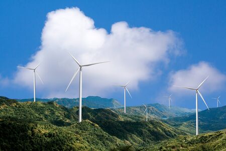 Beautiful green meadow with Wind turbines generating electricity