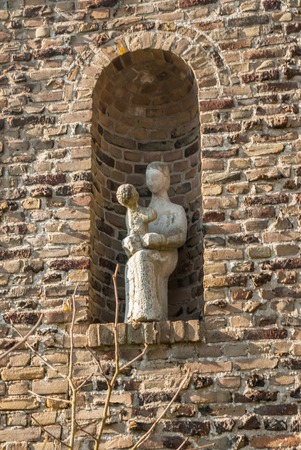Niche with sitting statue of St. Mary with playing child Jesus on lapのeditorial素材