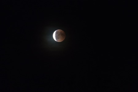 Partial lunar eclipse in dark night skyの写真素材