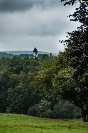 Landscape with trees and view on building with white bell tower. Breinig, DEのeditorial素材