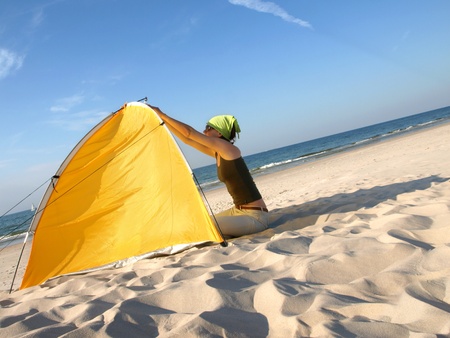 Young woman sitting at colorful beach tent.の写真素材