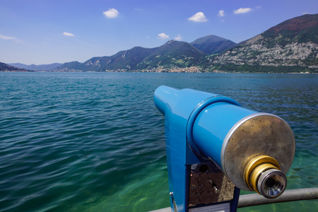 Public binocular telescope (binoscope) on the top of observation deck - view to the mountains landscape and lakeの写真素材